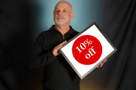 white bearded man holding advertisement board, advertising board, gentleman in black shirt colored backgroundの写真素材