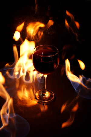 shot of drink with fire in the background with reflection drink red pepper hot imageの写真素材