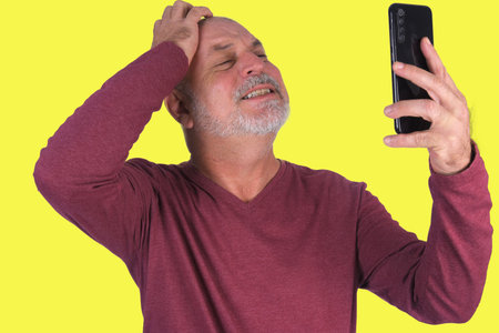 man holding cell phone, ideal for advertisement of discount bald man isolated on yellow backgroundの写真素材