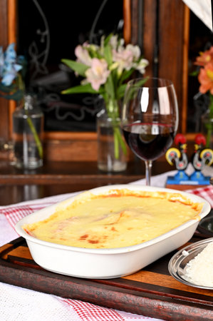 bolognese lasagna baked with cheese ham red sauce spices and meat with french fries and riceの写真素材