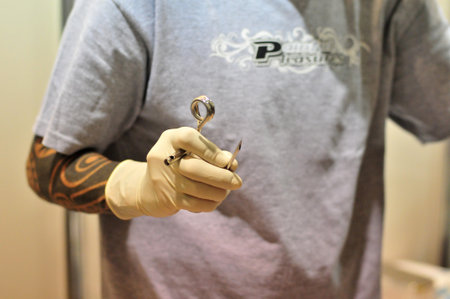 Goiania Skin piercing tattoo convention hanging equipment with metal hook hang bright metal hook on hands surgeon glovesのeditorial素材