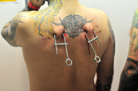 Goiania Skin piercing tattoo convention hanging equipment with metal hook hang bright metal hook on hands surgeon glovesのeditorial素材