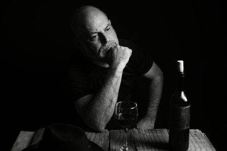 man sitting drinking wine face expression black and white photo with silhouette adult drinkの写真素材