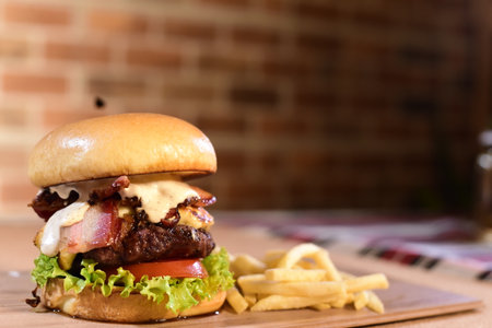 beef burger with sandwich bun salad onion and cheese fast food isolated on wooden table imageの写真素材