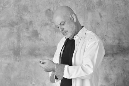 portrait of charming man in black and white shirt with gray beard and bald head modelの写真素材