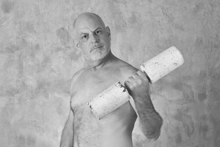 portrait of charming man lifting rustic weights practicing exercise modelの写真素材