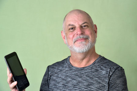 portrait adult man bald white beard face expression happy thoughtful male model gentleman in modern clothes image with cell phone.の写真素材