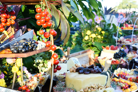 table cheeses paes finger food grapes and salads party buffet wedding decoration dishes flowers arrangements restaurant dining table imageの写真素材
