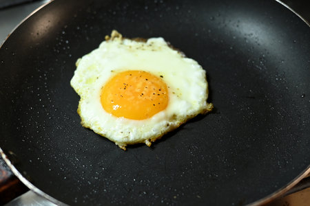 fried egg in frying pan healthy food runny yolk iamge