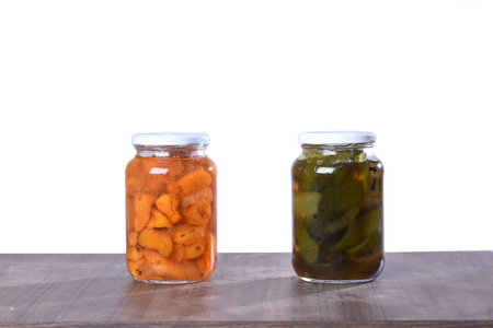 canned cashew and orange in a glass jar isolated, cashew halves in syrup, yellow fruit dessert, sweet peeled cashew and orange slices in syrup on a white backgroundの写真素材