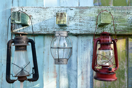 Old gas oil lamp. Hanging on old green and white wood.の写真素材