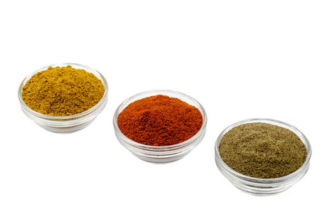 curry pepper and paprika in glass bowls isolatedの写真素材