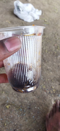Empty glass of soft drinks. Hand holding plastic disposal glassの写真素材