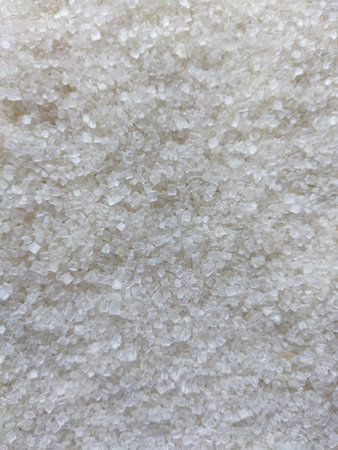 Texture background of spilling sugar. White sugar crystals background