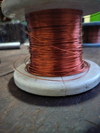 Spool of copper wire on a wooden background, close-upの写真素材