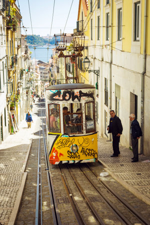 LISBON - MAY 01, 2016: Old yellow funicular on narrow street of Lisbon, Portugalのeditorial素材