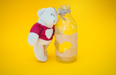 Bear and bottle on yellow background. St. Valentine's Day decorationの写真素材