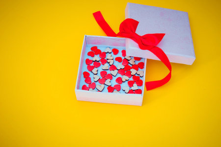 Gift box with small hearts on yellow backgroundの写真素材