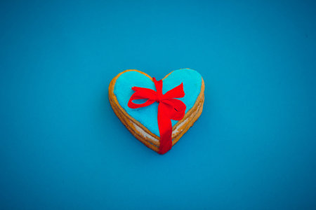 Homemade heart shape cookies with red ribbon on blue backgroundの写真素材