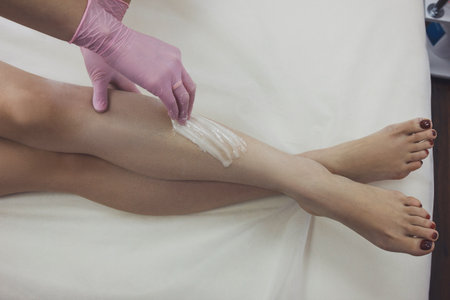 Woman using sugaring paste to shave legsの写真素材