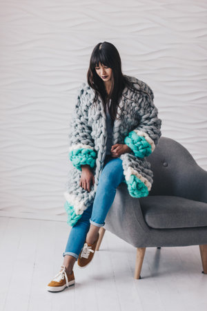 Beautiful young woman in grey long knitted merino wool cardiganの写真素材