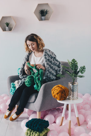 Young beautiful woman knittig green merino woolの写真素材