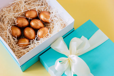 Golden Easter eggs in the straw in geen gift boxの写真素材