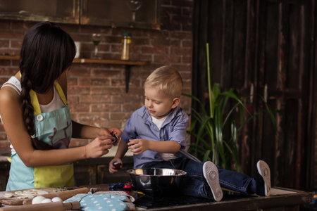 Mom with her 2 years old son cooking holiday pie in the kitchenの写真素材
