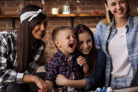 Two young women and two kids - boy and girl - have fun in the kitchenの写真素材