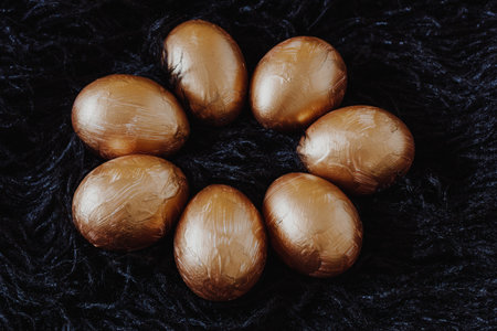 Golden Easter eggs on the black fur backgroundの写真素材