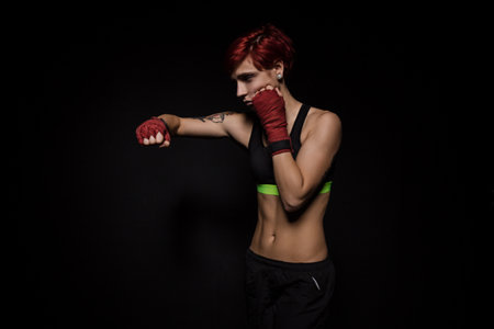 Boxing woman with red boxing wraps on black backgroundの写真素材