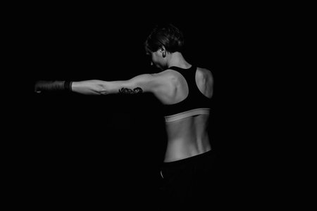 Boxing woman with boxing wraps on black background. Black and white shotの写真素材
