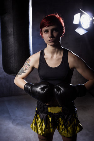Young boxing woman with boxing gloves on black backgroundの写真素材