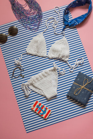 Knitted white swimsuit on stripped background. Top shotの写真素材