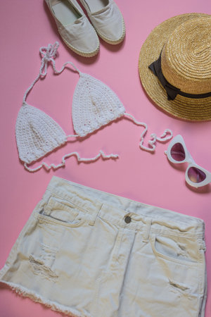 Knitted white top and jeans skirt on pink background. Top shotの写真素材