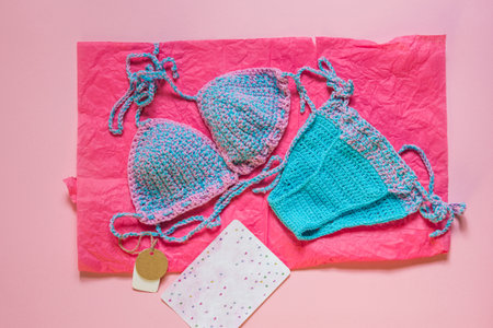 Knitted blue swimsuit on pink background. Top shotの写真素材