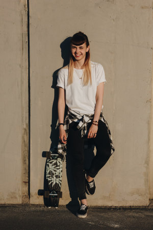 Smiling hipster girl with skate board. Full length portraitの写真素材