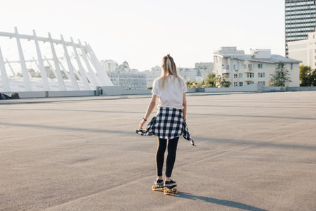 Hipster girl riding skate board in the city