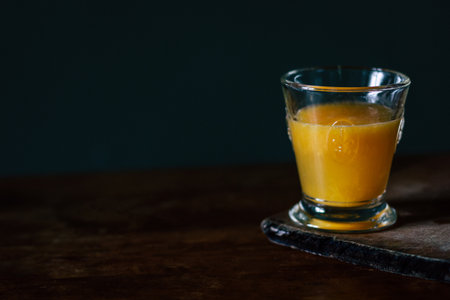 Fresh orange juice in glass on wooden table