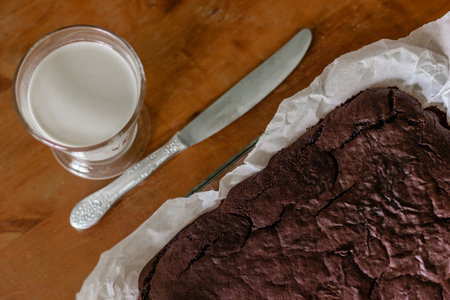 Homemade chocolate brownie with glass of milk on kitchen tableの写真素材