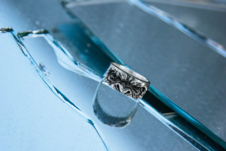 Ape shape silver ring on glass backgroundの写真素材