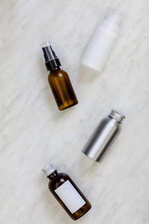 Cosmetic bottles and containers with blank label for branding mock-up on marble tableの写真素材
