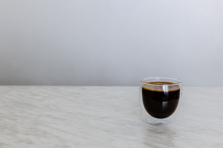 Glass with coffee on marble tableの写真素材