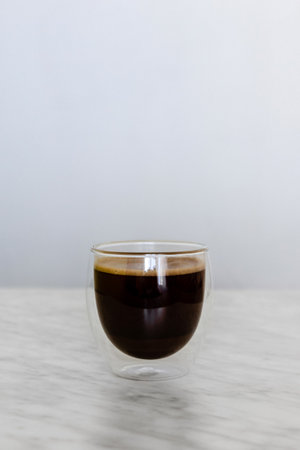 Glass with coffee on marble tableの写真素材