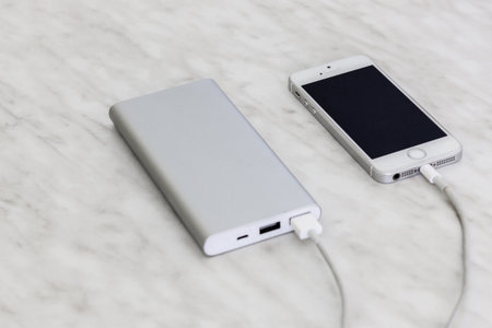 Phone charging with power bank on marble background
