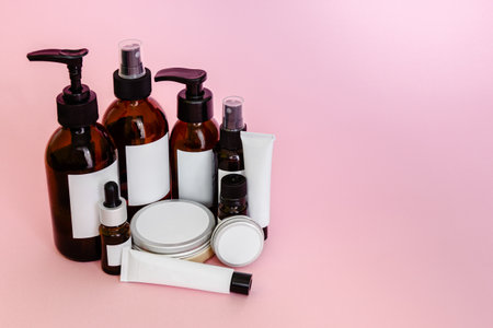 Cosmetic bottles and containers with blank labels for branding mock-up on pink backgroundの写真素材