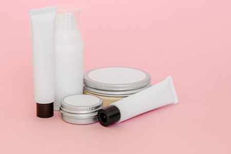 Cosmetic bottles and containers with blank labels for branding mock-up on pink backgroundの写真素材