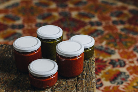 Sauce in a glass jars on wooden tableの写真素材