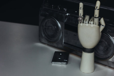Robot hand with silver scull shape ring making rock sign with cassette and tape recorderの写真素材