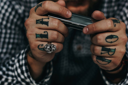 Close up of tattooed man holding harmonicaの写真素材